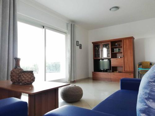 a living room with a blue couch and a tv at Wish Apartments in Poreč