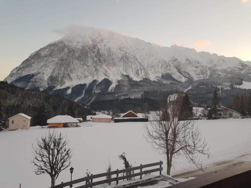 a snow covered mountain with a village and a fence at Ferienwohnung Arina in Tauplitz
