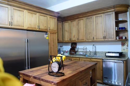a kitchen with wooden cabinets and a wooden table with a refrigerator at Casa Maricela B&B in San Miguel de Allende