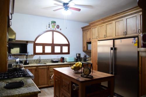 a kitchen with wooden cabinets and a stainless steel refrigerator at Casa Maricela B&B in San Miguel de Allende