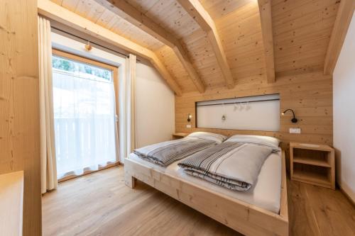 un letto in una camera con una grande finestra di Lüch Picedac a La Valle