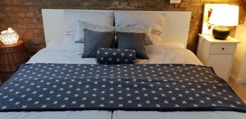 a bed with a blue blanket with white stars on it at Kelsterhaus in Kelsterbach