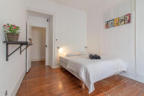 a bedroom with a white bed and a wooden floor at Party Zone in Lisbon