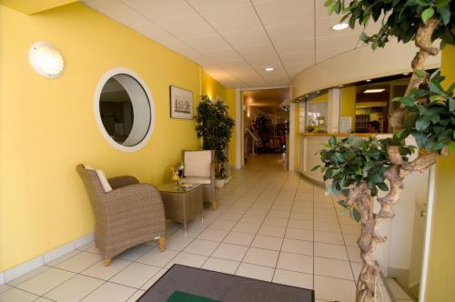 an office lobby with a chair and a mirror at Le Robinson in Saint-Jean-de-Monts