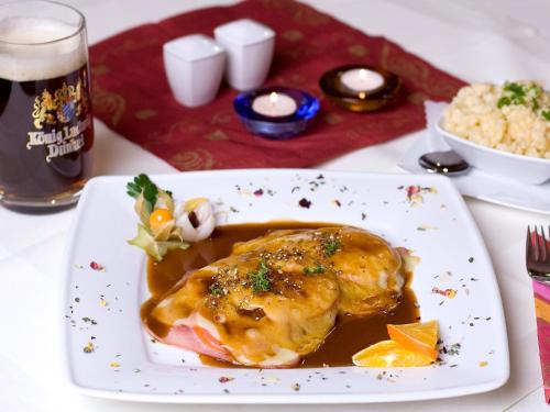 a plate of food with a chicken in a sauce at Gasthof Rössle in Rieden am Forggensee