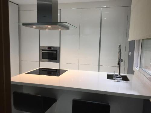 une cuisine blanche avec un évier et une cuisinière dans l'établissement Sevilla Aljarafe Room, à Bormujos