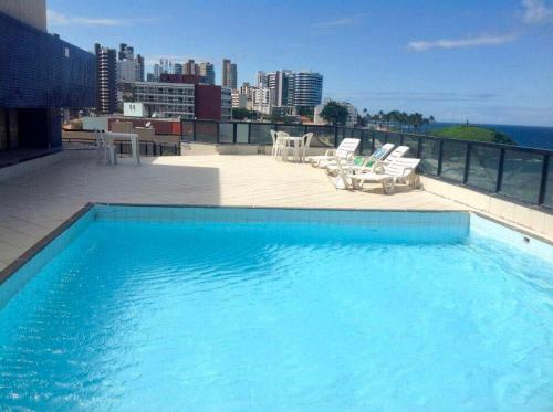 a large blue swimming pool on top of a building at Flat Farol da Barra 2 in Salvador