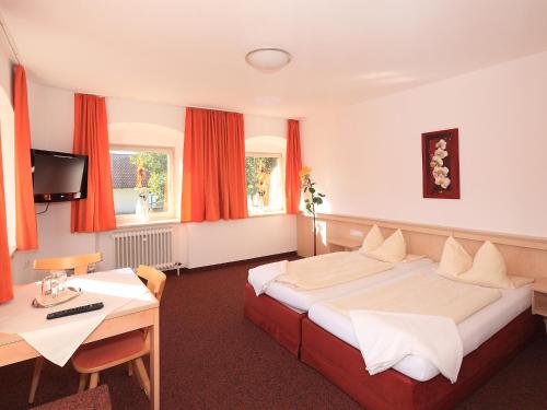 リーデンにあるガストホフ レーズレのベッドとデスクが備わるホテルルームです。