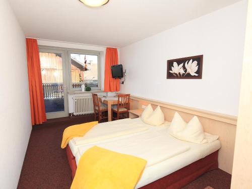 a hotel room with a bed and a table and a window at Gasthof Rössle in Rieden am Forggensee