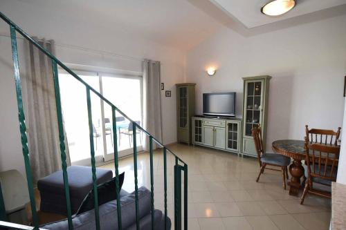 a living room with a staircase and a television at Wish Apartments in Poreč
