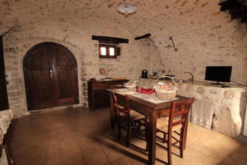 a kitchen with a table with chairs and a sink at Residenza La Torre in Santo Stefano di Sessanio