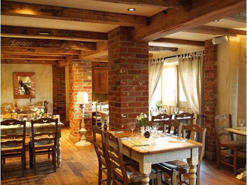 ein Esszimmer mit Tischen und Stühlen und einer Ziegelwand in der Unterkunft The Broad Leys in Aylesbury