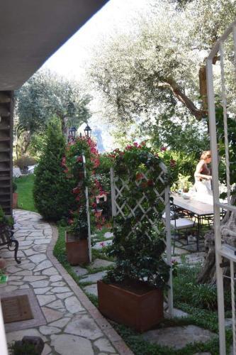 a woman sitting at a table in a garden at La Palombara B&B in Vico Equense