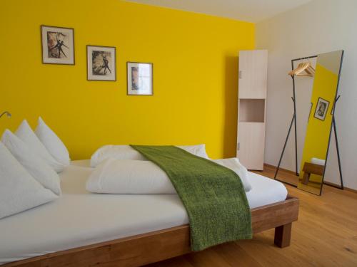 1 dormitorio con 1 cama con pared amarilla en B&B perron13, en Murten
