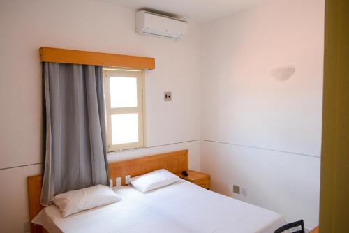 a bedroom with two beds and a window at Hotel Villa Real in Sobral