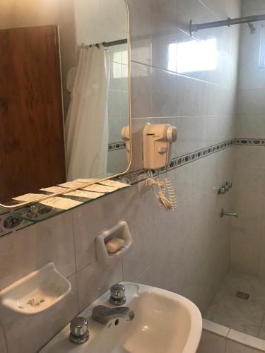 un baño con lavabo y espejo en Onais Hotel, en Mar de Ajó