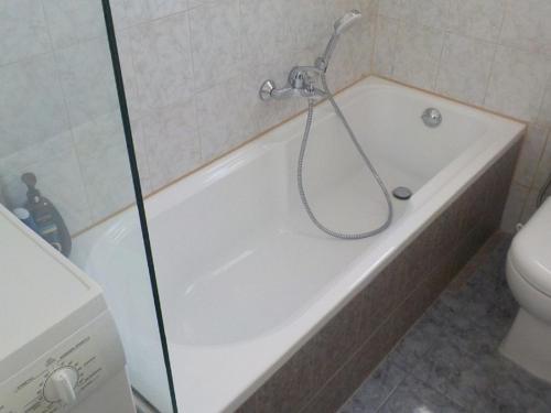 a white bath tub with a shower in a bathroom at *OI.KO HOUSE* City Apartments in Kato Achaia