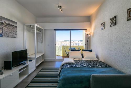 カスカイスにあるCozy Studio with balcony and beautiful viewのベッドルーム1室(ベッド1台、大きな窓付)