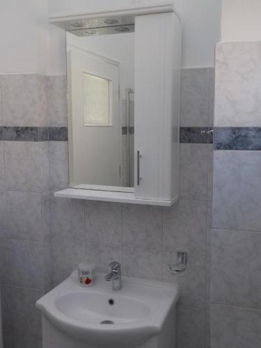 a bathroom with a sink and a mirror at *OI.KO HOUSE* City Apartments in Kato Achaia