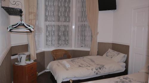 a small bedroom with a bed and a window at Hornby House Hotel in Blackpool