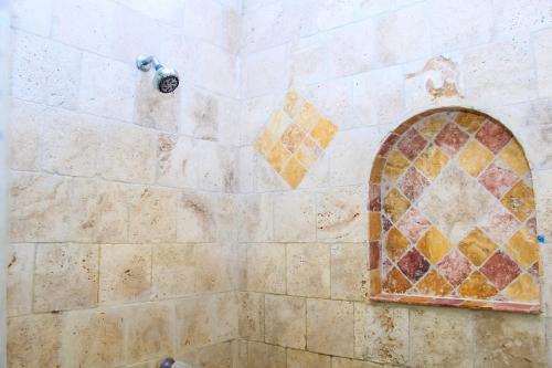 a bathroom with a shower with a mosaic window at Sunset Villa 3F by Splash Inn in Sandy Bay