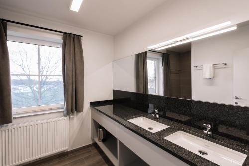 a bathroom with two sinks and a large mirror at Duins Genot 5 star Holiday Homes 30p & 40p - Indoorpool & Wellness in Jabbeke