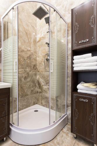 a shower with a glass enclosure in a bathroom at Hotel Baron in Odesa