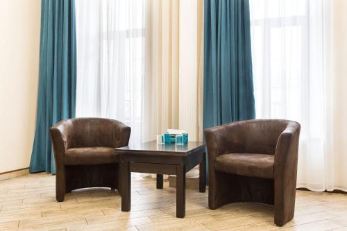 two chairs and a table and a table and chairs at Hotel Baron in Odesa