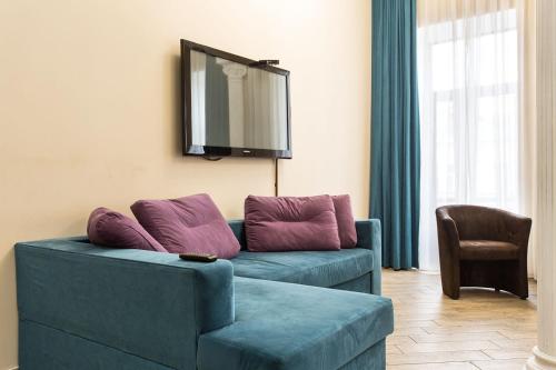 a blue couch with purple pillows in a living room at Hotel Baron in Odesa