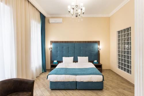 a bedroom with a large bed with a blue headboard at Hotel Baron in Odesa