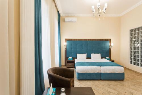 a hotel room with a bed and a table at Hotel Baron in Odesa