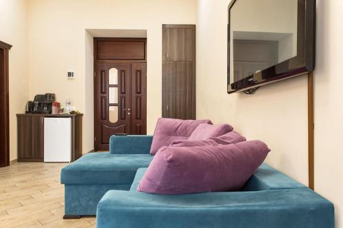 a living room with two blue couches and a mirror at Hotel Baron in Odesa