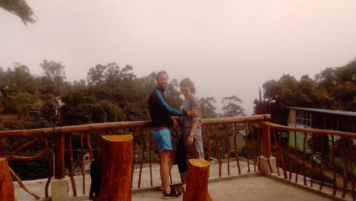 a man and a woman standing on top of a balcony at Green View Ella in Ella