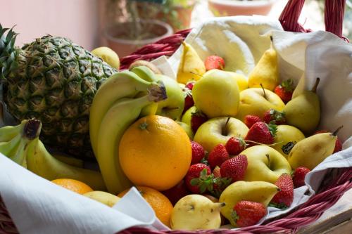 a basket of fruit with bananas oranges and strawberries at Country Hotel & Resort I Calanchi in Ripatransone