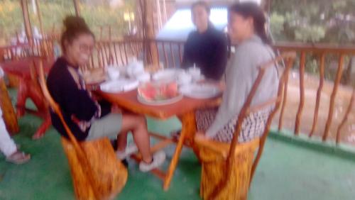 a group of people sitting at a table on a porch at Green View Ella in Ella