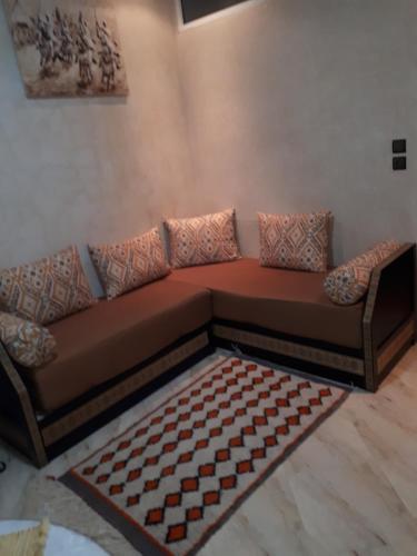 a brown couch in a living room with a rug at Mirleft Point in Mirleft