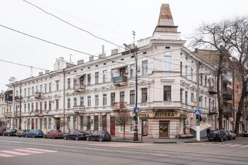 duży biały budynek po stronie ulicy w obiekcie Hotel Baron w Odessie