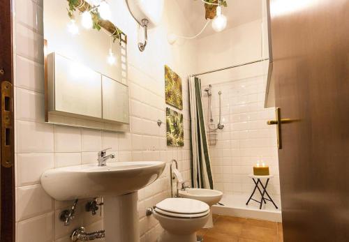 La salle de bains blanche est pourvue d'un lavabo et de toilettes. dans l'établissement City Jungle, à Viterbe