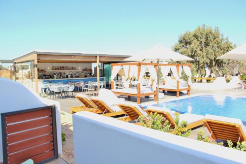 a pool with chairs and tables and umbrellas at Ifestos Villa in Fira