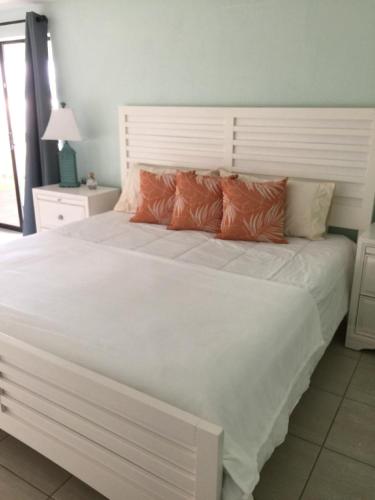 a bedroom with a large white bed with orange pillows at Edgewater Lodge in Layton