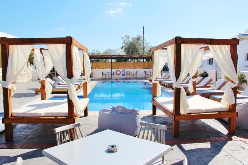 a resort with a pool and chairs and a table at Ifestos Villa in Fira