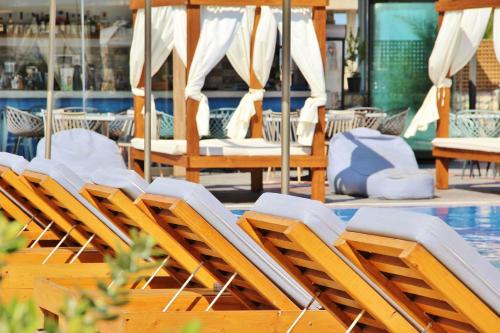 a group of chairs sitting next to a swimming pool at Ifestos Villa in Fira