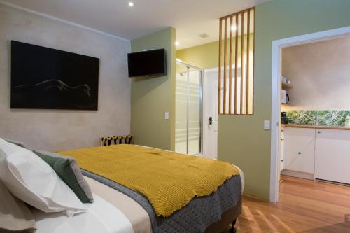 a bedroom with a bed with a yellow blanket on it at Woodstock Suite in Nelson