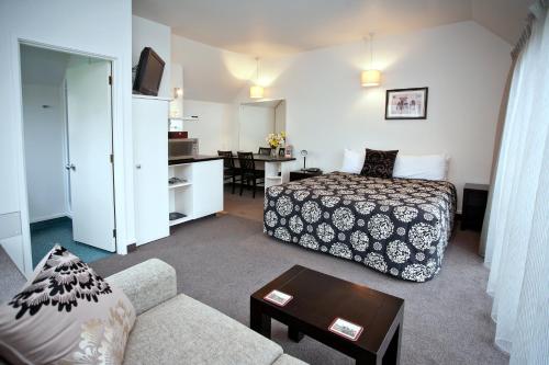 a hotel room with a bed and a couch at Cable Court Motel in Dunedin