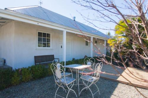 a patio with a table and chairs in front of a house at Woodstock Suite in Nelson