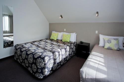 a bedroom with two beds and two pillows at Cable Court Motel in Dunedin