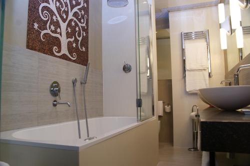 a bathroom with a bath tub and a sink at c-hotels Rubens in Milan