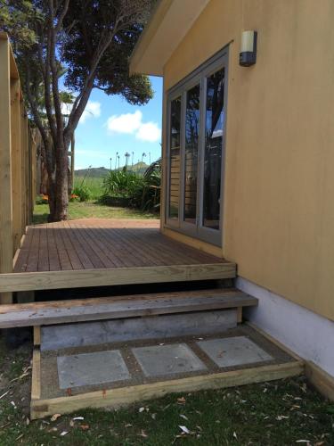 an entrance to a house with a porch and a door at Chalet Cullen, in Mangawhai