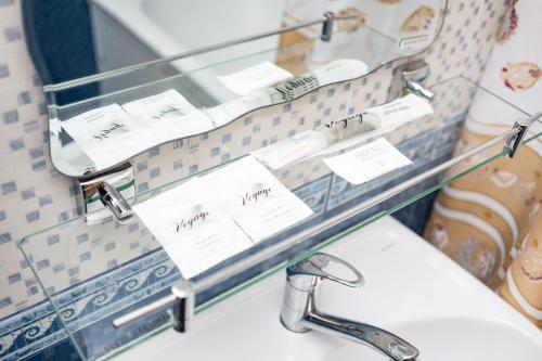 estante de cristal sobre un lavabo en el baño en Arirang Hotel, en Khabarovsk