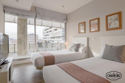 two beds in a hotel room with a balcony at Charming Eurobuilding 2 Exclusive in Madrid